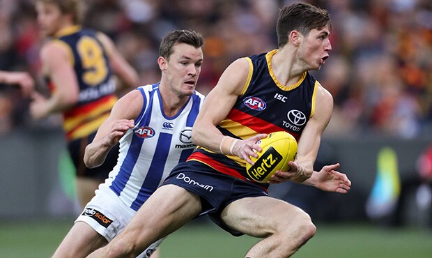 AFL 2018 Round 22 - Adelaide v North Melbourne ADELAIDE, AUSTRALIA - AUGUST 19: Jake Kelly of the Crows evades the tackle from Kayne Turner of the Kangaroos during the 2018 AFL round 22 match between the Adelaide Crows and the North Melbourne Kangaroos at Adelaide Oval on August 19, 2018 in Adelaide, Australia. (Photo by AFL Media)